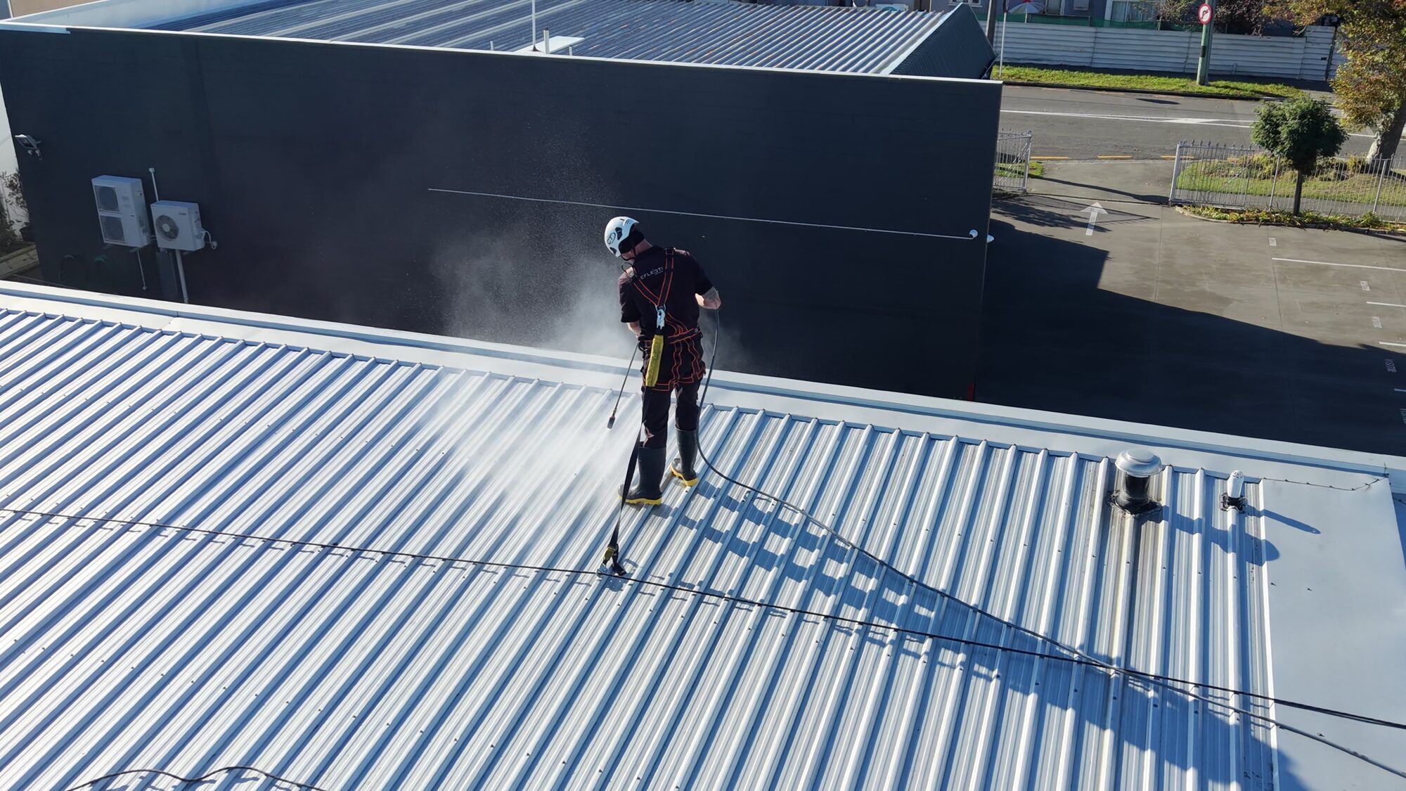 Peak Property Care technician working at height on a commercial roof in New Zealand